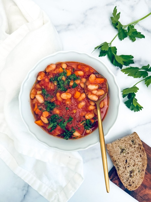 A bowl of tomato and white bean stew.
