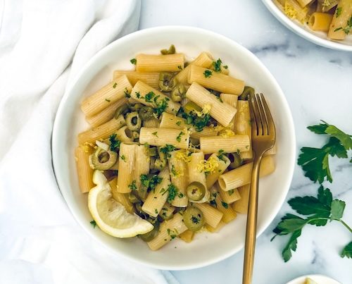 A bowl of green olive pasta.