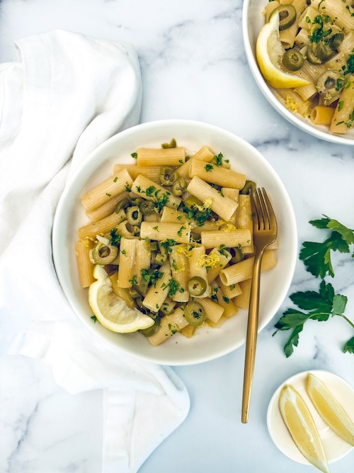 A bowl of green olive pasta.