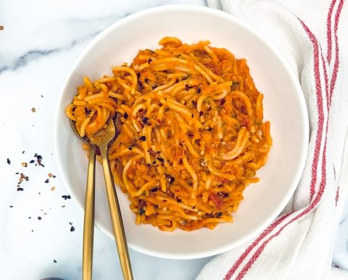 A bowl of red lentil pasta.