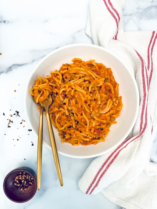 A bowl of red lentil pasta.