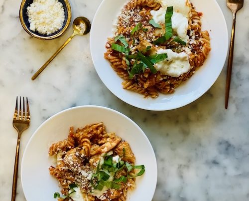 Two bowls of chicken parmesan pasta.