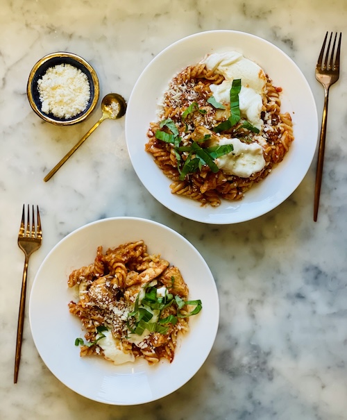 Two bowls of chicken parmesan pasta.