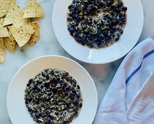 Two bowls of coconut black beans with kale.