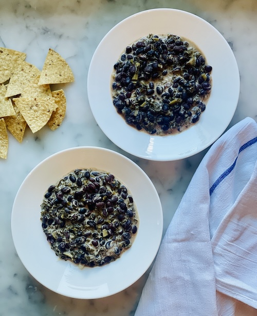 Two bowls of coconut black beans with kale.
