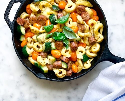 Tortellini sausage bake in a cast iron skillet.