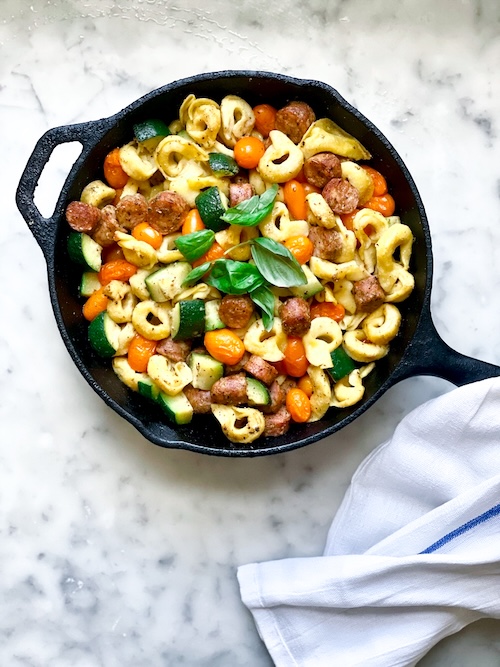 Tortellini sausage bake in a cast iron skillet.