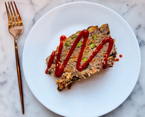 A slice of chipotle cheddar meatloaf on a plate.