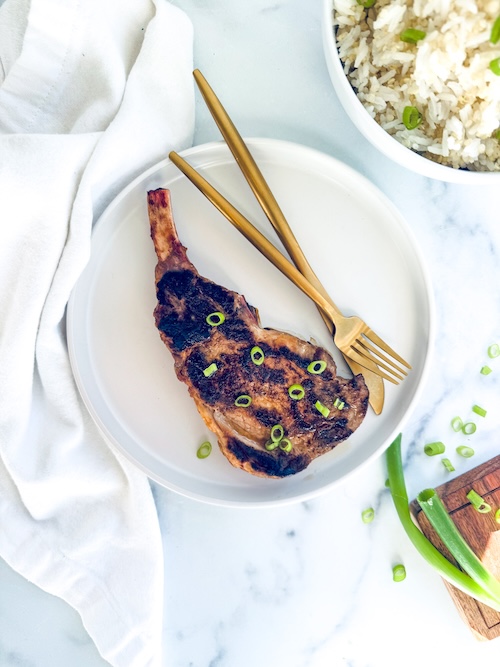 Grilled bone-in pork chop on a plate.