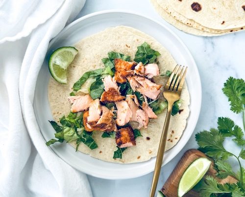 Salmon taco on a plate.
