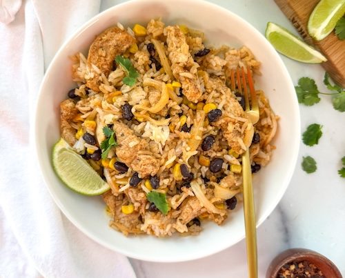 A bowl of chicken fajitas with rice.