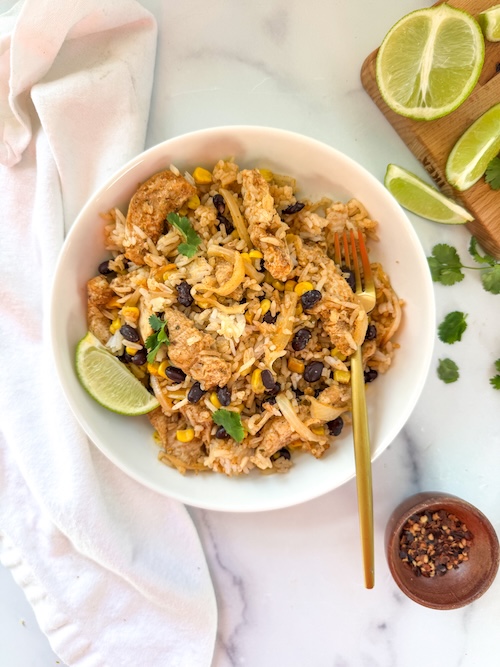 A bowl of chicken fajitas with rice.
