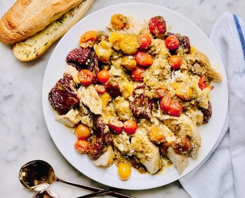 Pesto chicken and tomatoes on a plate.