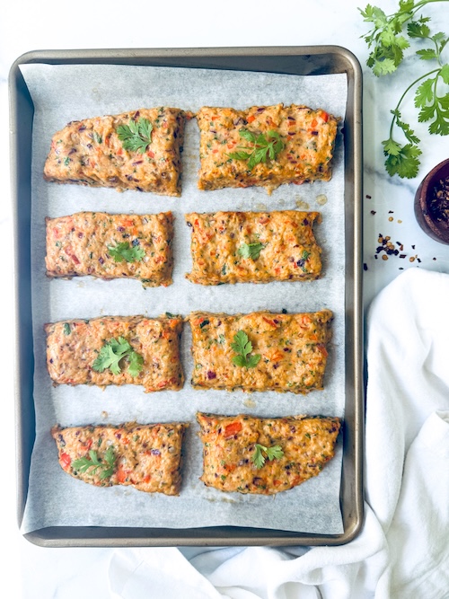 Ground chicken patties on a sheet pan.