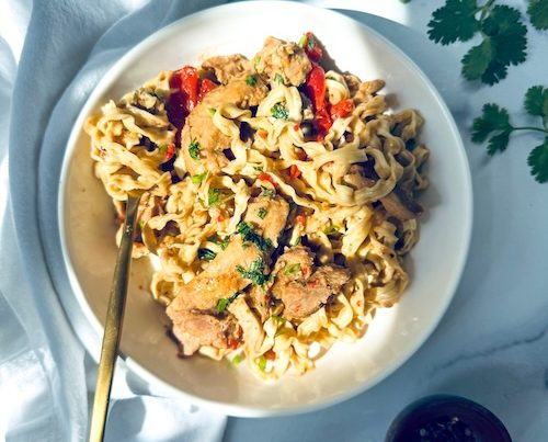 Thai peanut chicken over a bowl of noodles.