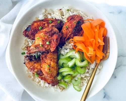 Chicken wings, carrots, and celery over rice.