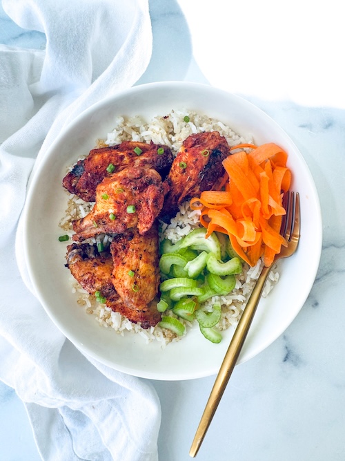 Chicken wings, carrots, and celery over rice.