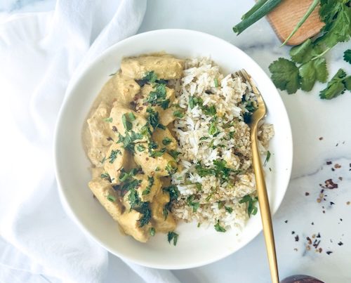 A bowl of peanut chicken with rice.