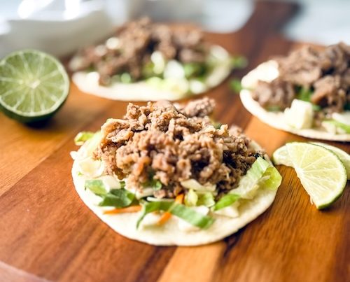 Shaved steak fajitas on a wood board.