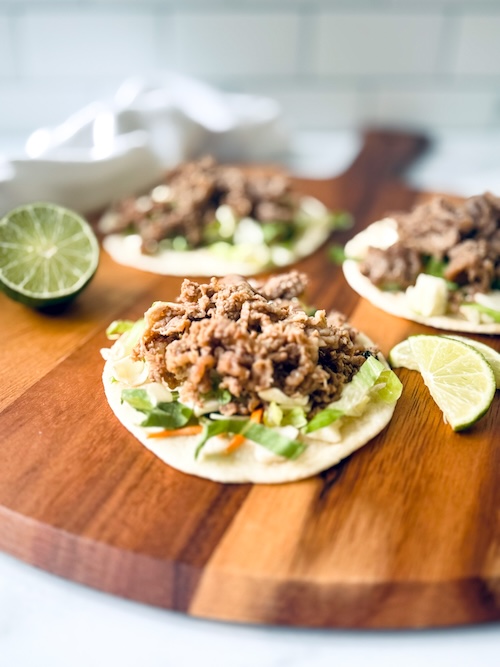 Shaved steak fajitas on a wood board.