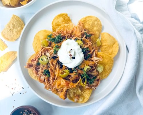 Shredded chicken nachos on a plate.