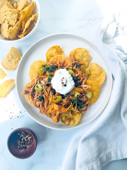Shredded chicken nachos on a plate.
