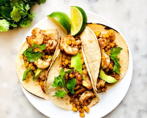 Chipotle shrimp and corn tacos on a plate.