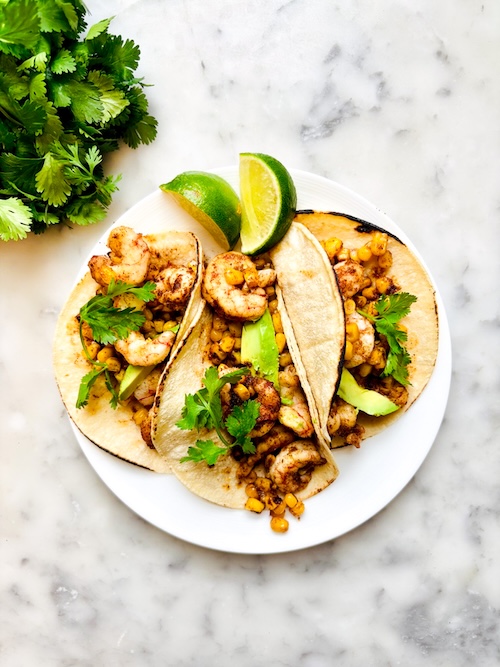 Chipotle shrimp and corn tacos on a plate.