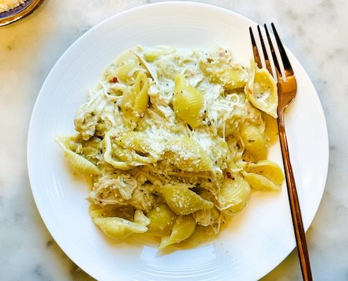 A bowl of creamy chicken artichoke pasta.