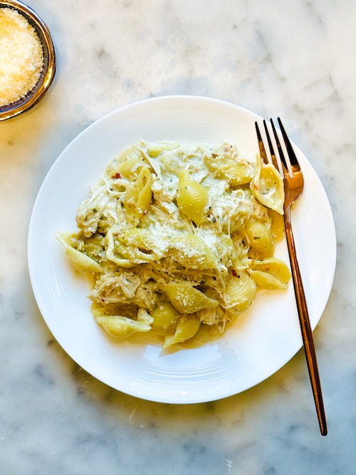 A bowl of creamy chicken artichoke pasta.