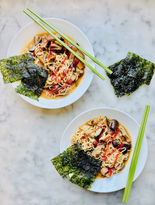 Two bowls of spicy mushroom ramen noodles.
