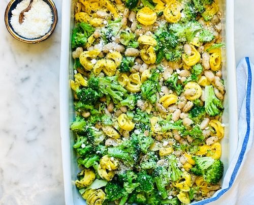 Baked tortellini with broccoli and beans in a baking dish.