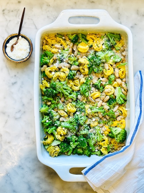 Baked tortellini with broccoli and beans in a baking dish.