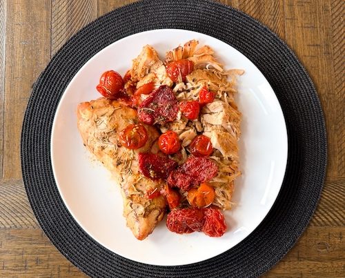 Turkey tenderloin with tomatoes on a plate.