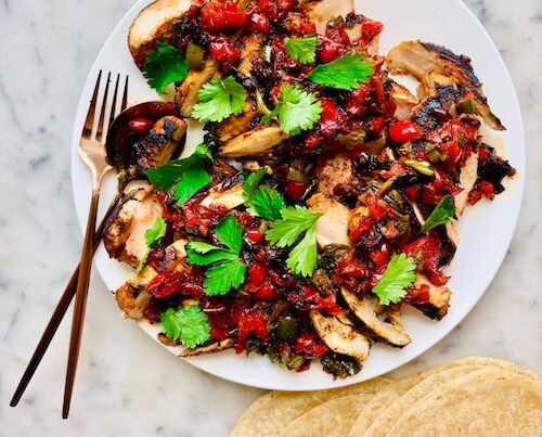 Grilled chicken coated with salsa and topped with cilantro.