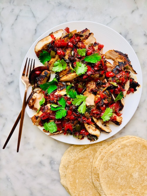 Grilled chicken coated with salsa and topped with cilantro.