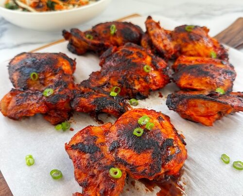 Harissa honey chicken thighs with green onions.