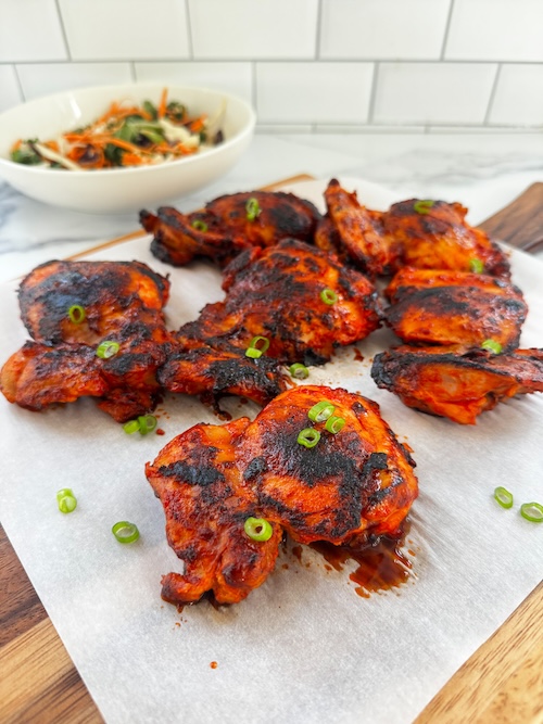 Harissa honey chicken thighs with green onions.