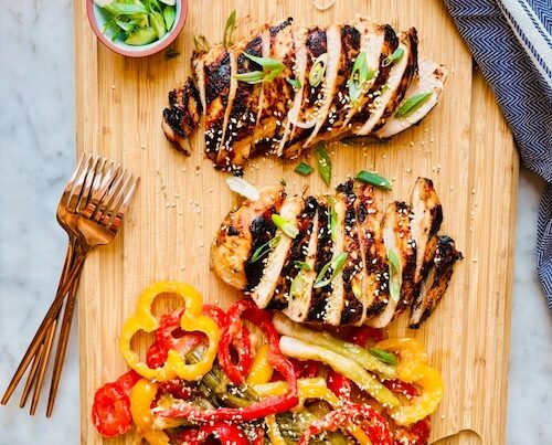 Sliced miso chicken on a wooden cutting board.