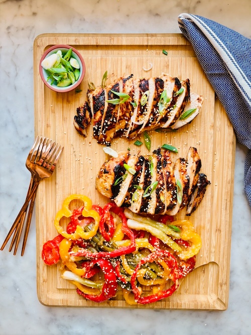 Sliced miso chicken on a wooden cutting board.