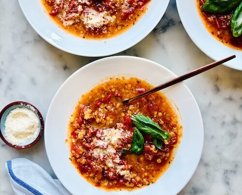 Three bowls of tomato lentil soup.