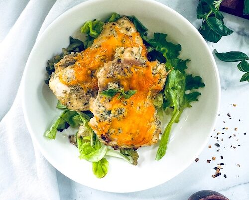 Oven baked chicken topped with cheddar cheese.