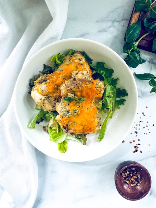 Oven baked chicken topped with cheddar cheese.