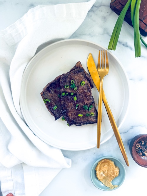 Miso butter skirt steak on a plate.