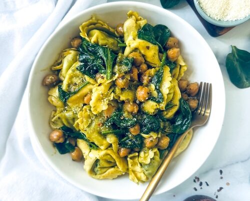 Pesto tortellini and chickpeas in a bowl.