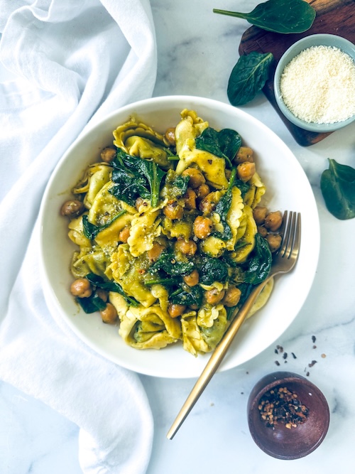 Pesto tortellini and chickpeas in a bowl.