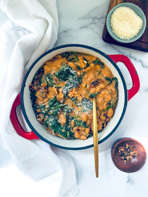 Cast iron pot of tuscan white beans with kale.