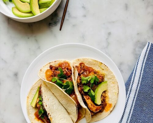 Mango chicken tacos on a plate.