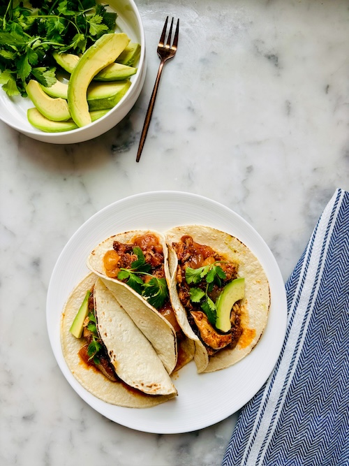 Mango chicken tacos on a plate.